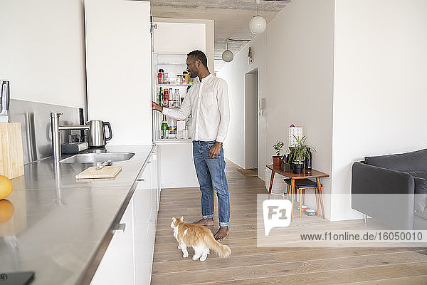 Man standing in the kitchen looking into fridge