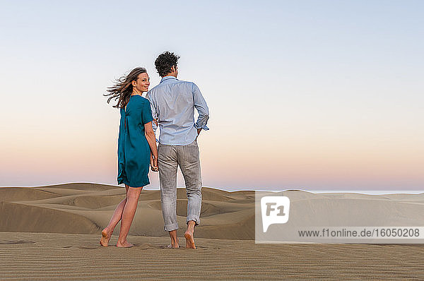 Affectionate couple walking in the dunes at sunset  Gran Canaria  Spain