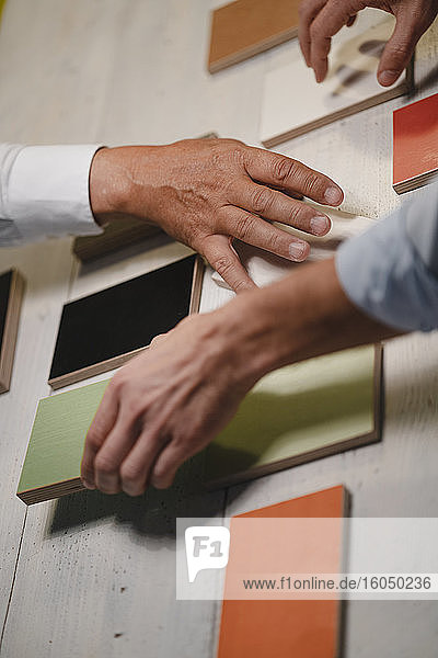 Hands of architects choosing colour samples in office