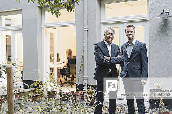 Zwei erfolgreiche Geschäftsleute stehen auf dem Hinterhof ihres Büros