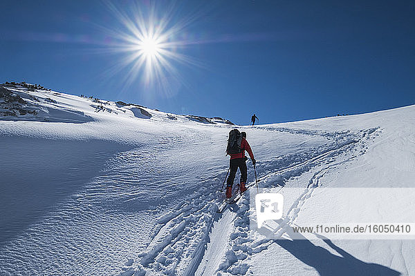 Älterer Mann beim Skifahren auf dem schneebedeckten Dachstein gegen den Himmel an einem sonnigen Tag  Österreich