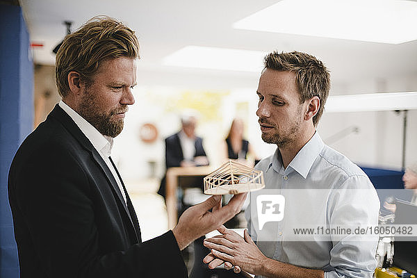 Architects looking at model of modern building