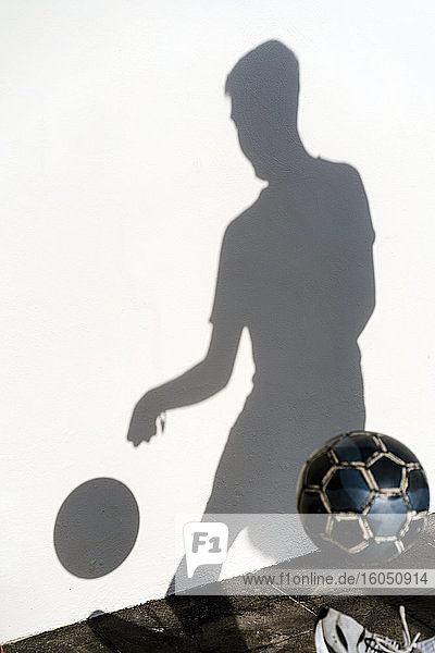 Schatten eines Mannes  der mit Fußball trainiert