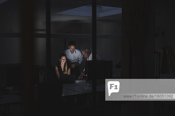 Ein Team von Geschäftsleuten arbeitet bis spät in die Nacht im Büro  um Lösungen zu diskutieren