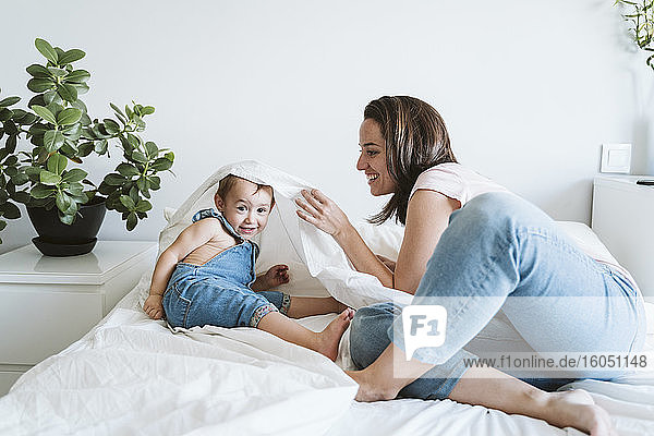 Mother playing with baby girl at home