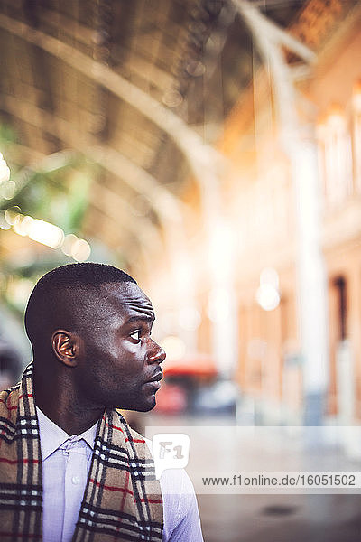 Serious thoughtful businessman looking away while standing at station