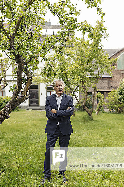 Confident senior businessman standing in a rural garden