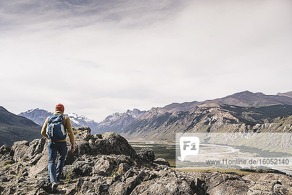 Mann mit Rucksack wandert auf Felsen gegen den Himmel  Patagonien  Argentinien
