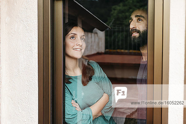 Ein Paar schaut aus dem Fenster und denkt an die Zukunft