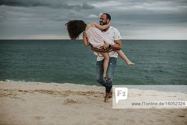 Glücklicher Vater mit Tochter am Strand