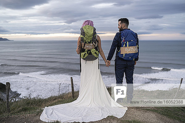 Brautpaar auf Aussichtspunkt und Meer im Hintergrund