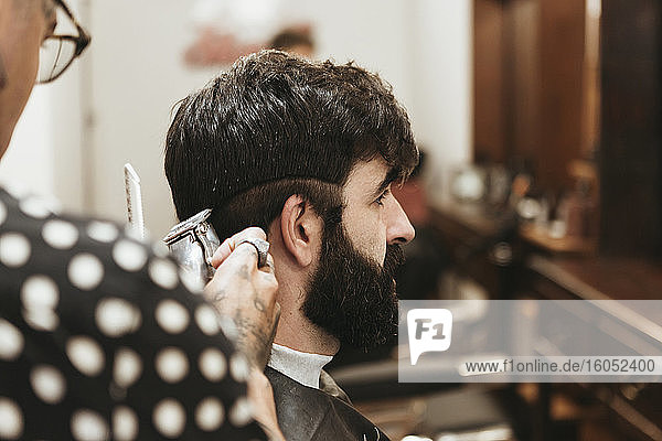 Friseur schneidet einem Mann die Haare im Salon