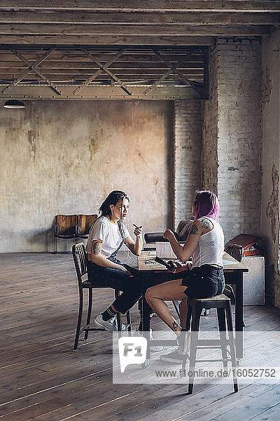 Zwei kreative Geschäftsfrauen im Gespräch im Loftbüro