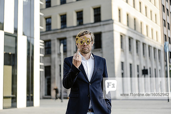 Geschäftsmann mit 2020-Comedy-Brille in der Stadt  der den Finger zeigt