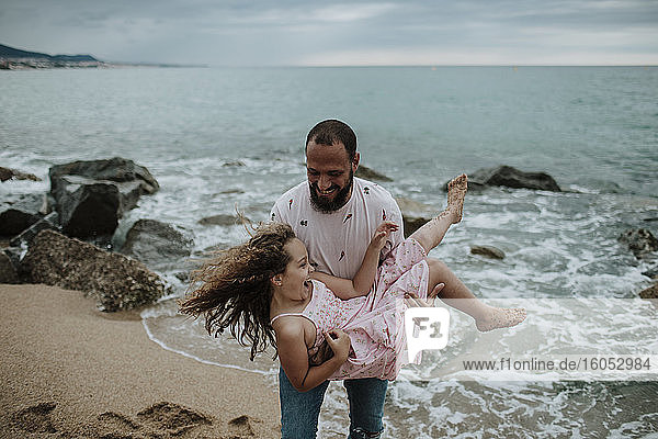 Lächelnder Vater mit Tochter am Strand