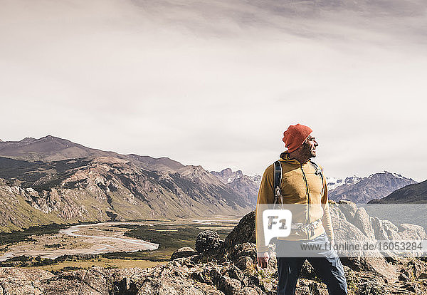 Männlicher Wanderer  der wegschaut  während er gegen Berge in Patagonien  Argentinien  steht