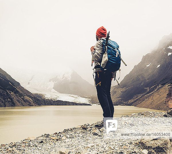 Man with backpack standing by lake against sky at Patagonia  Argentina