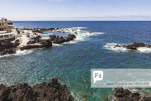 Portugal  Porto Moniz  Small rocky bay along shore of Madeira Island with clear line of horizon over Atlentic Ocean in background
