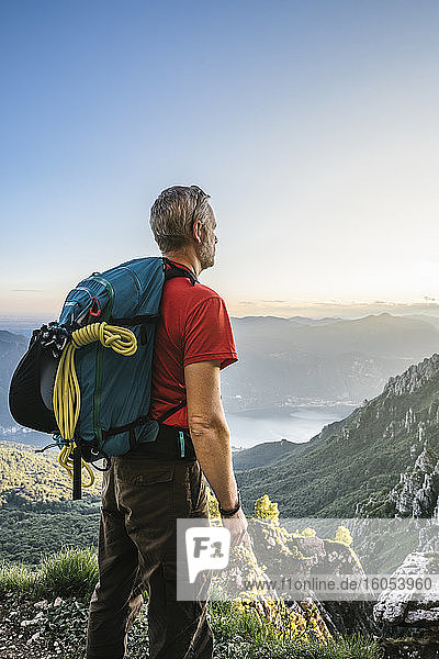 Wanderer mit Rucksack und Blick auf die Berge gegen den klaren Himmel bei Sonnenuntergang  Orobie  Lecco  Italien