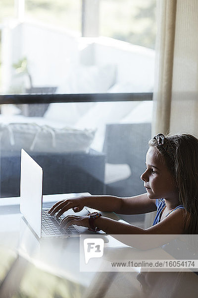 Girl using laptop at home