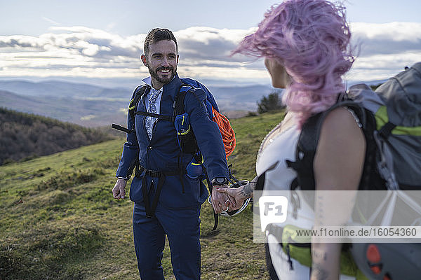 Brautpaar mit Kletterrucksäcken vor dem Berg Urkiola  Spanien