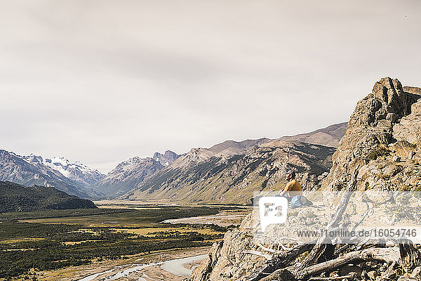 Männlicher Wanderer sitzt auf einem Felsen in den patagonischen Anden  Argentinien