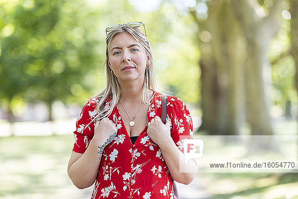 Selbstbewusste Frau im öffentlichen Park an einem sonnigen Tag