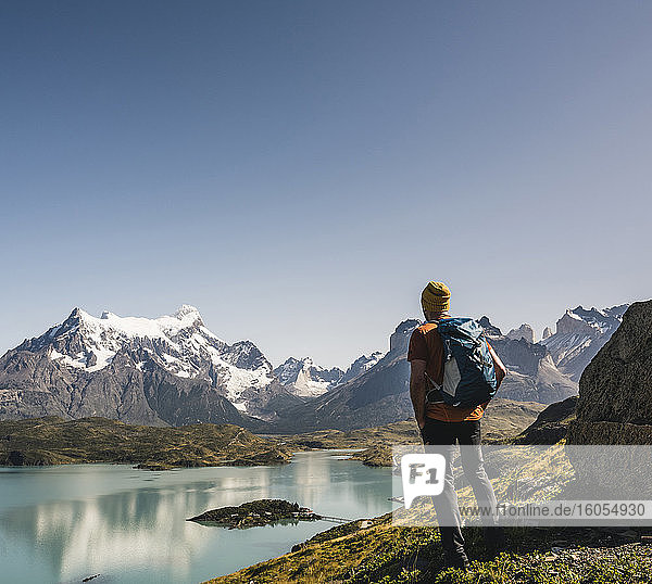 Man with backpack looking at lake against clear sky  Torres Del Paine National Park  Patagonia  Chile