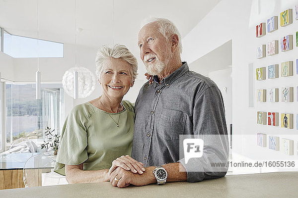 Lächelndes Seniorenpaar in einer Luxusvilla