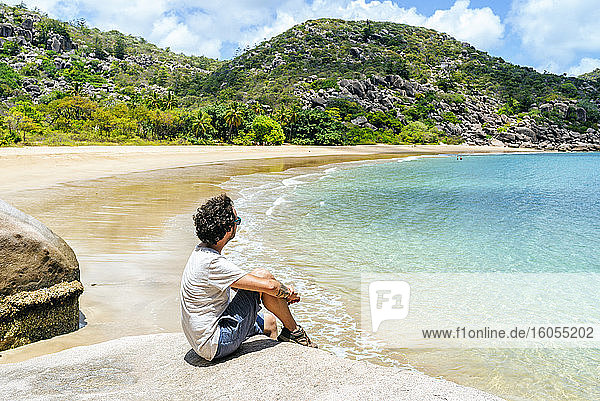 Mann sitzt auf einem Felsen bei Magnetic Island  Queensland  Australien