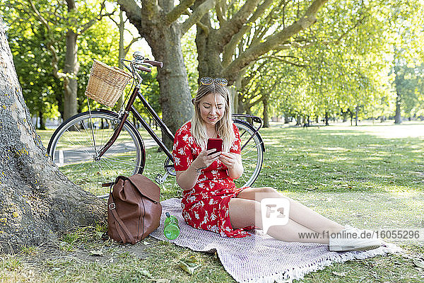 Frau benutzt Smartphone in einem öffentlichen Park