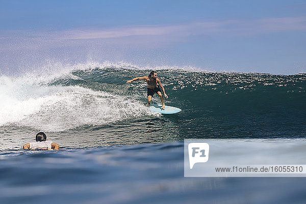 Mann ohne Hemd beim Surfen auf dem Meer gegen den Himmel  Bali  Indonesien