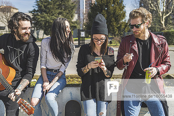 Mittlere erwachsene Frau benutzt ein Smartphone  während sie mit Freunden in der Stadt steht