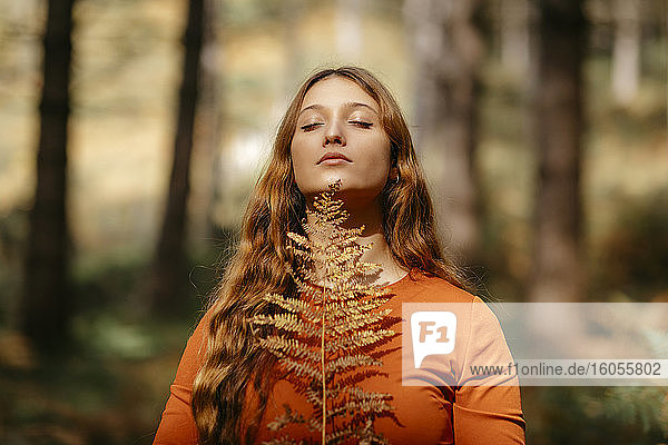 Nahaufnahme einer schönen Frau mit langen blonden Haaren im Wald stehend