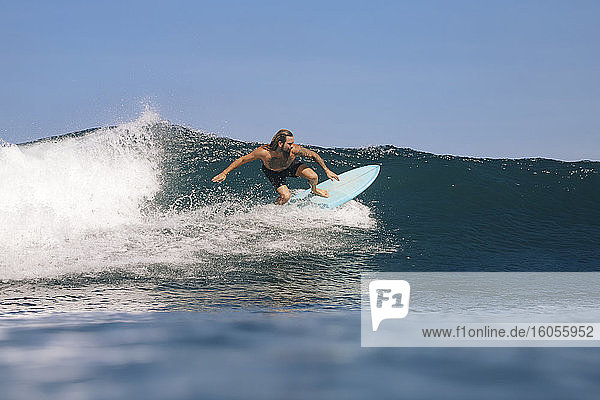 Hemdsärmeliger erwachsener Mann beim Surfen auf dem Meer gegen den klaren Himmel  Bali  Indonesien