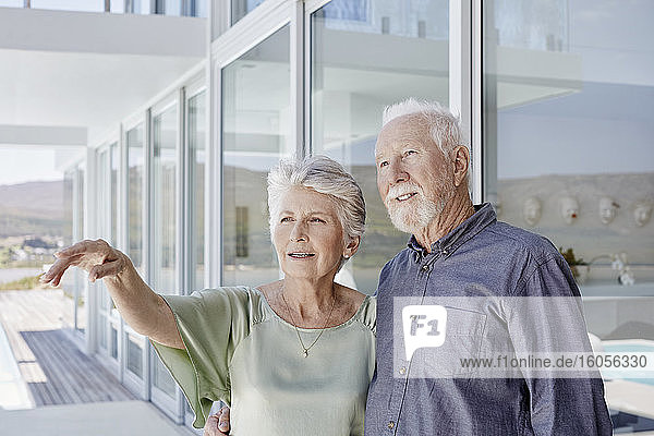 Porträt eines älteren Paares in einem luxuriösen Strandhaus mit Blick auf die Aussicht