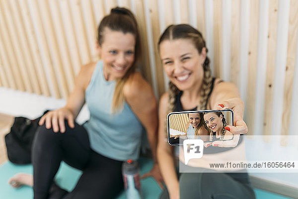 Zwei sportliche Frauen machen ein Selfie im Fitnessstudio