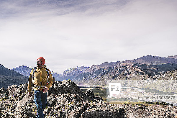 Männlicher Wanderer  der in Patagonien  Argentinien  auf Felsen gegen Berge läuft