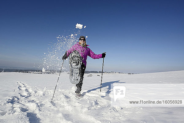 Female hiker kicking snow toward camera