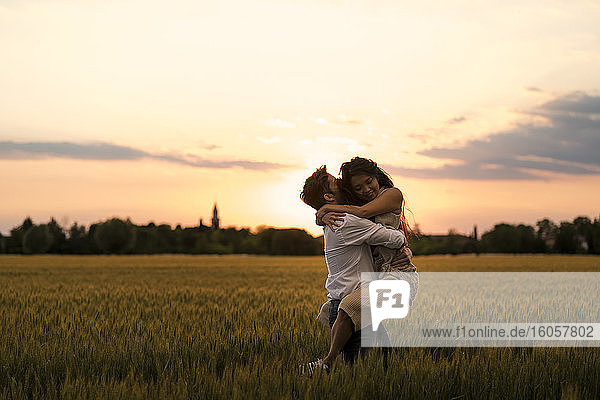 Dancing couple on field during sunset