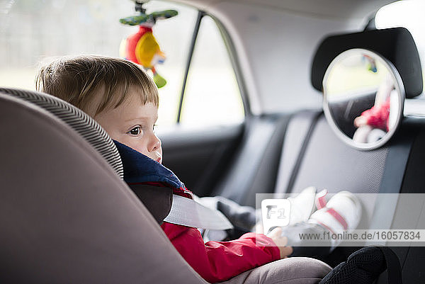 Babyjunge schaut weg  während er auf dem Autositz sitzt
