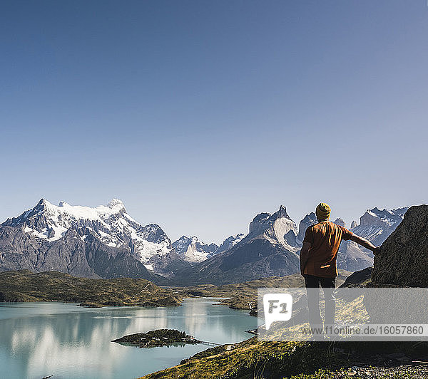 Male hiker standing by lake against clear sky at Torres Del Paine National Park  Patagonia  Chile