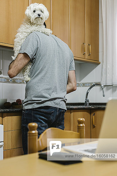 Mann mit Hund beim Kochen in der Küche