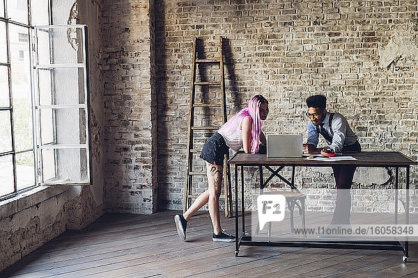 Two creative business people having a meeting in loft office