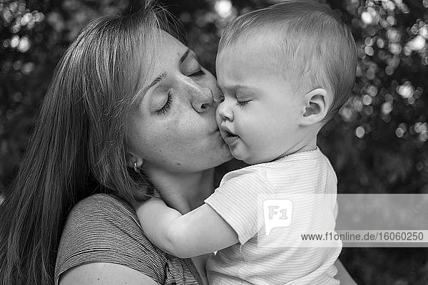 Eine Mutter  die ihr kleines Mädchen auf die Wange küsst; Surrey  Britisch-Kolumbien  Kanada