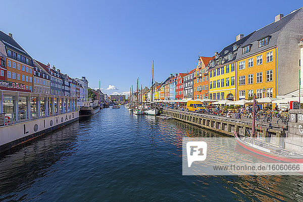 Boote und Menschen entlang einer farbenfrohen Uferpromenade namens Nyhavn; Kopenhagen  Dänemark