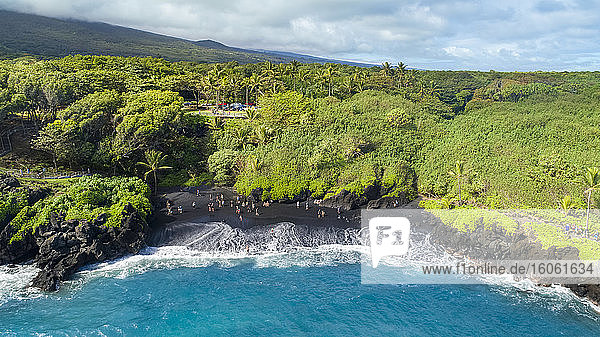 Touristen am schwarzen Sandstrand des Waianapanapa State Park  Hana  Maui  Hawaii  Vereinigte Staaten von Amerika