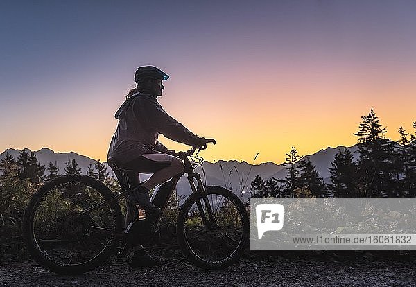 Silhoutte einer Mountainbikerin in Abenddämmerung  hinten Bergkulisse  Patscherkofel  Patsch  Tirol  Österreich  Europa