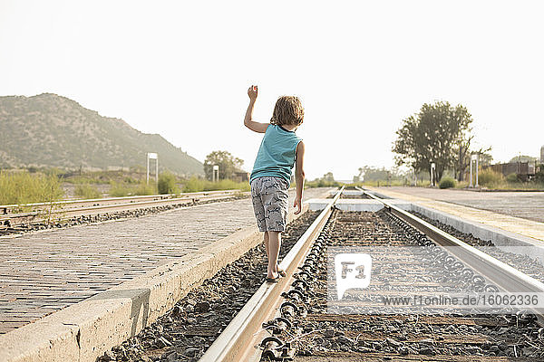 4 Jahre alter Junge balanciert auf der Eisenbahnschiene Lamy NM.