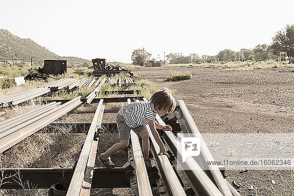 4 Jahre alter Junge spielt auf den Eisenbahnschienen Lamy NM.